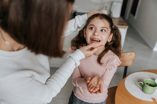 Mother and daughter in the kitchen after a tooth extraction