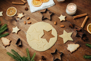 Christmas cookie dough cutting with star shapes and tree cookies for holiday food and festive baking concept