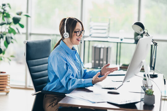 Young businesswoman wearing a headset working in a modern office during a professional video conference meeting