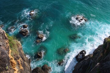 High angle view of turquoise ocean water crashing over rocks
