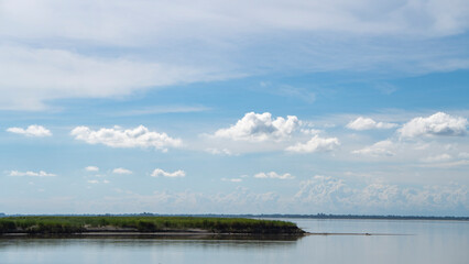 Beautiful sub-tropical Brahmaputra river bank with tall grass canopy and cloudscape in the background wide frame 6