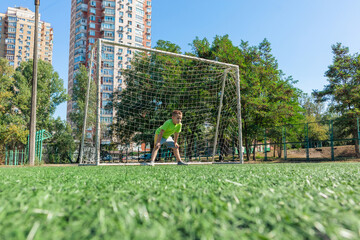 Boy goalkeeper on a school football field
