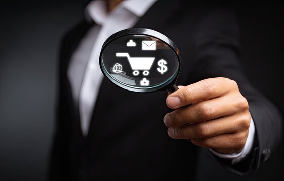 Businessperson holding magnifying glass focusing on a shopping cart icon with related icons