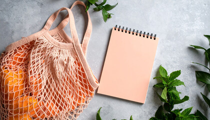 Summer flat lay on a concrete background Peach notepad and an eco-friendly mesh shopping bag