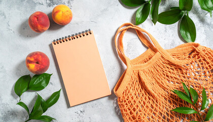 Summer flat lay on a concrete background Peach notepad and an eco-friendly mesh shopping bag