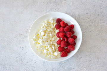 Cottage cheese with fresh raspberries in a white bowl