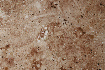 Textured surface with brown and white paint splatters in a creative workspace