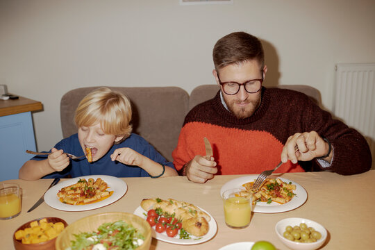 Father and son enjoying dinner together at home