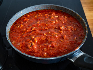 Cooking bolognese sauce in frying pan	