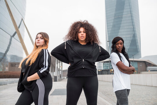 Three sportive young women posing in the city