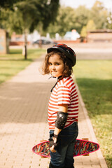 Cute kid girl child riding a skateboard in skatepark. Summer sport activity concept. Happy childhood.