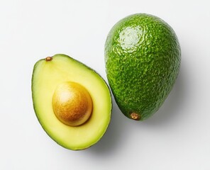 Two avocados, one whole and one halved, atop a white surface