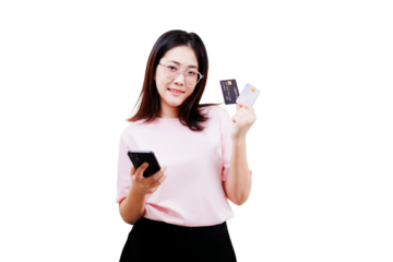 Asian young beautiful woman wearing glasses holds a smartphone in one hand and two credit cards in the other, smiling confidently.