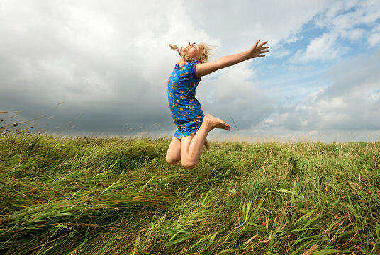 Joyful girl jumping in agricultural field