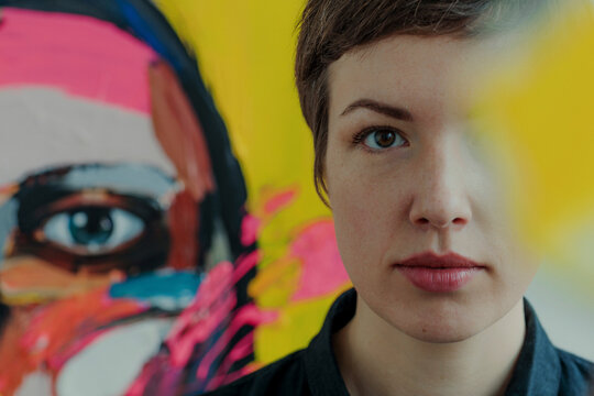 Portrait of a female painter with painting in background