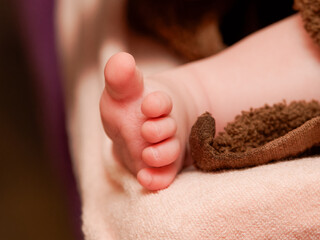 Gros plan sur les orteils d’un bébé allongé sur une serviette douce, instant de calme et de...