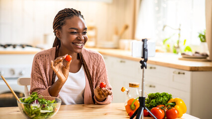 Food Blogger. Smiling young african american female vlogger recording video in kitchen, using...