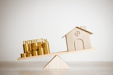 A pile of gold coins with the words interest outweighs homes on the scale. Concept of rising home interest rate risk, refinancing, and money management. 3D rendering