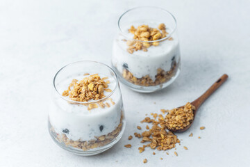 Yogurt parfait with granola and blueberries in glass cups