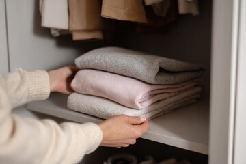 Hands organizing clothes in closet