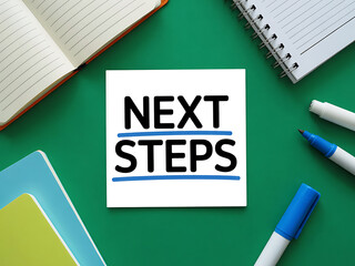 Planning the next steps with notebooks and markers on a green surface