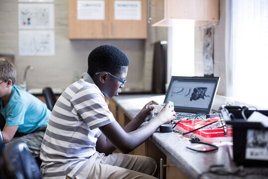 Schoolboys with laptop in robotics class