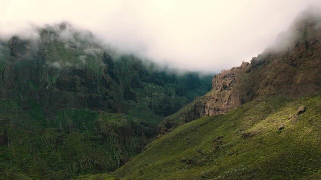 Aerial view of lush green cliffs near Masca with sun rays breaking through clouds, Tenerife, Canary Islands