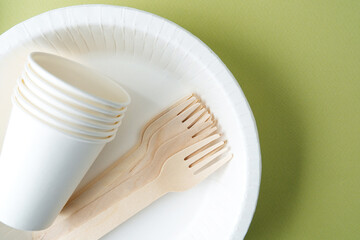 White disposable tableware set on blue background with cups and forks