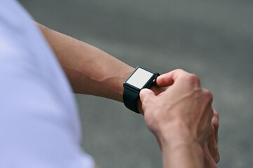 Close-up of a athlete setting up smartwatch for workout tracking, health monitoring, and...