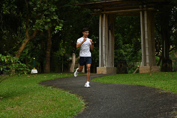 A Fit male runner in sportswear running outdoors in a natural setting, maintaining fitness and health