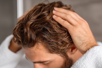 Fototapeta premium Man Applying Brown Glitter Hair Treatment In Bathroom