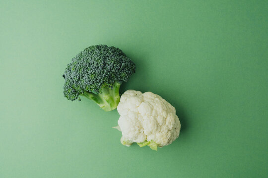 Fresh cauliflower and broccoli healthy vegetables on green background