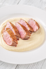 Sliced Fried Duck Breast Served with Mashed Potatoes on White Dinner Plate