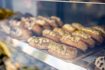 Puff pastry cake with cream and berries behind the glass display case of the refrigerator in cafe