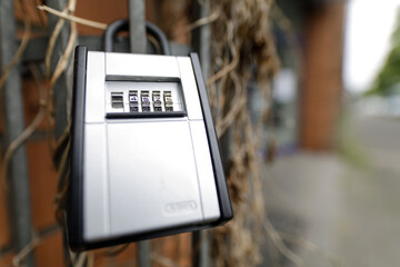 Close-up of a silver combination padlock secured to a metal fence. Ideal for security, safety, and...