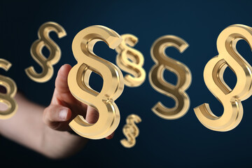 Hand reaching for 3D golden paragraph symbols. Legal, law, justice concept.