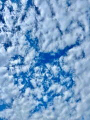 High-resolution sky texture with scattered white clouds on a vibrant blue background. Ideal for use...