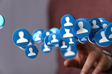 Image of a hand interacting with floating social media profile icons. Represents networking, community growth, and online connections.