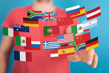 Image of a person interacting with a digital display of various national flags, symbolizing global...