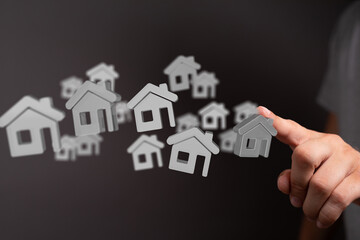 Hand interacting with 3D house icons. Perfect for real estate, property, and home search concepts.