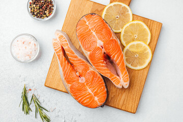 Bright salmon fillets laid out with lemon slices and spices ready for cooking