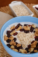 Healthy yogurt bowl with heart shape made of oats, nuts and dried cranberries