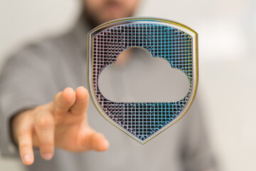 Hand reaching for a digital shield protecting cloud data.  Cybersecurity, data safety.