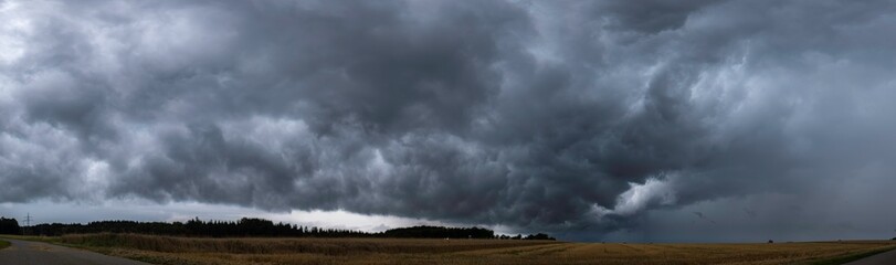 Panoramaaufnahme einer Gewitterwolke über einem Kornfeld.