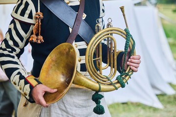 An ancient musical instrument trumpet of the 19th century in the hands of a musician in historical...