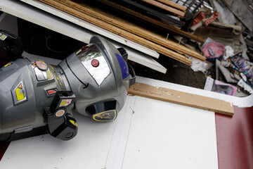 A discarded robot toy lies on construction debris, suggesting themes of abandonment, waste, or the...