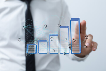 Stock photo of a businessman interacting with a digital bar chart showing growth and data connections.