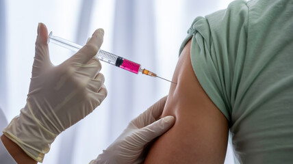 A close-up medical photograph of a vaccination injection being administered.
