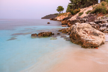 A beautiful beach with a large rock in the middle