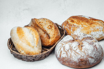 Freshly baked artisan bread displayed in a woven basket on a neutral background